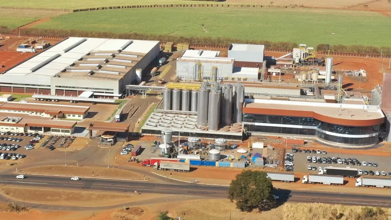 Instalação industrial com tanques, galpões e veículos de carga